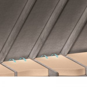 Close-up of beige roof tiles with small blue plastic fasteners along the edge.